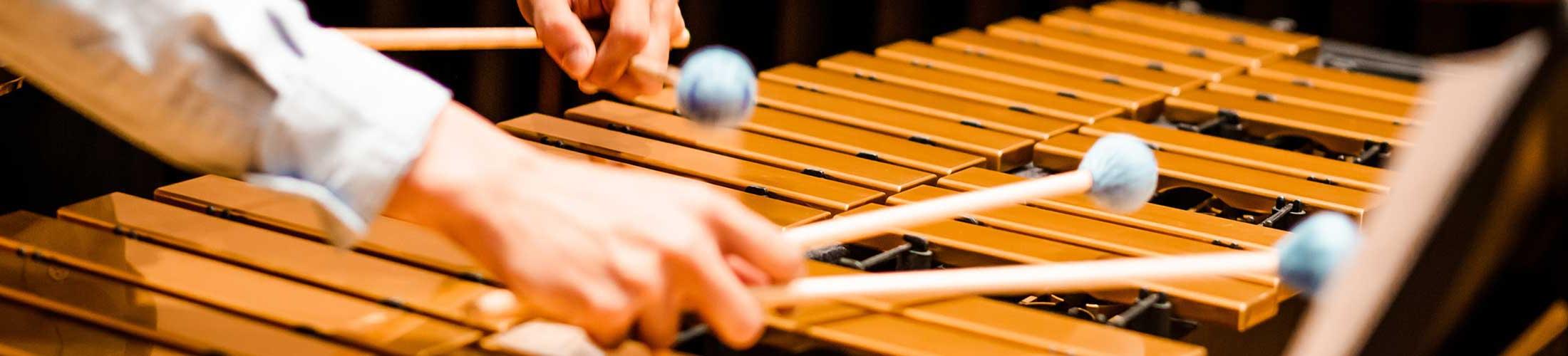 Hands playing on a percussion instrument.